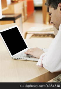 Side profile of a mature man using a laptop