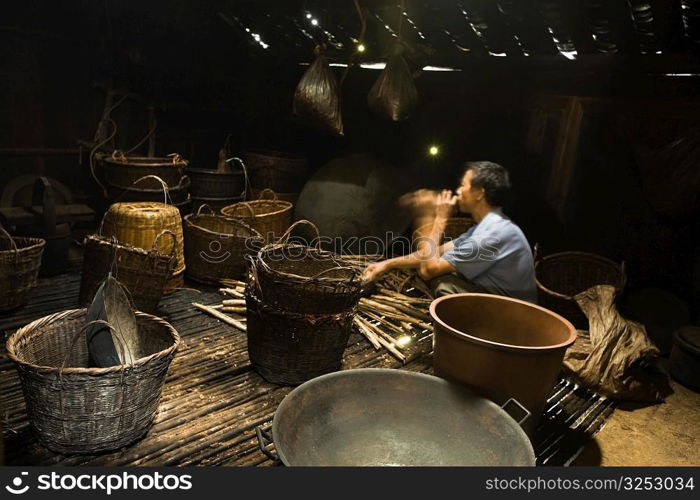 Side profile of a mature man weaving a bamboo basket, Jinkeng Terraced Field, Guangxi Province, China