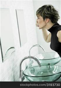 Side profile of a mature woman brushing her teeth