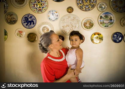 Side profile of a mature woman holding her granddaughter