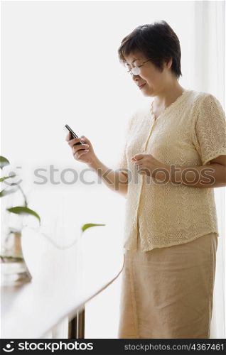 Side profile of a mature woman looking at a mobile phone
