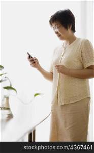 Side profile of a mature woman looking at a mobile phone