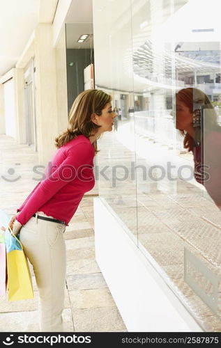 Side profile of a mature woman looking through a store window