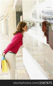 Side profile of a mature woman looking through a store window