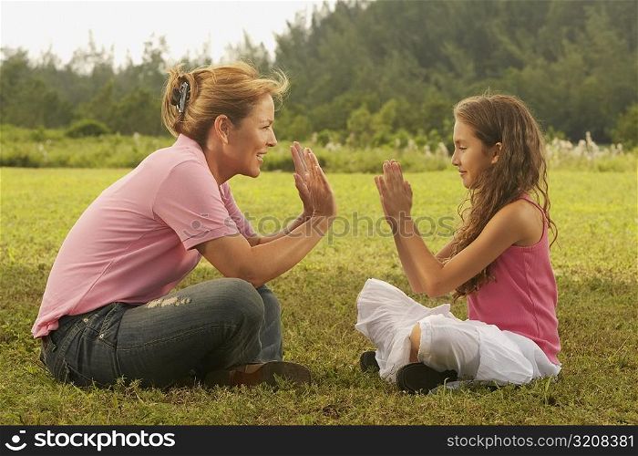 Side profile of a mature woman playing with her daughter in the park