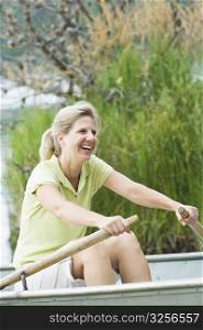 Side profile of a mature woman rowing a boat and smiling