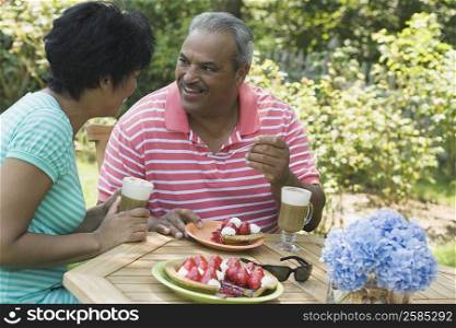 Side profile of a mature woman sitting with a senior man at the breakfast table