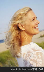 Side profile of a mature woman smiling on the beach