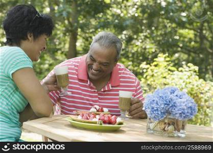 Side profile of a mature woman smiling with a senior man at the breakfast table