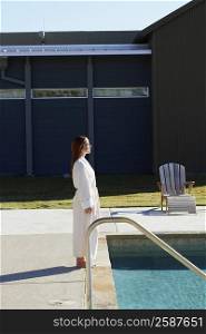 Side profile of a mature woman standing at the poolside