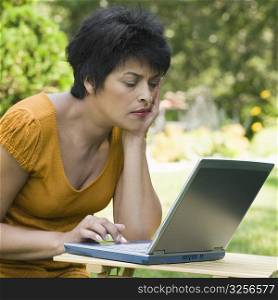 Side profile of a mature woman using a laptop