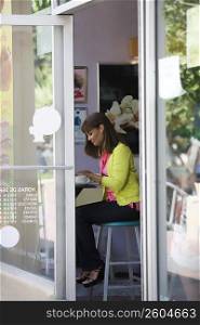 Side profile of a mature woman using a laptop in a cafe