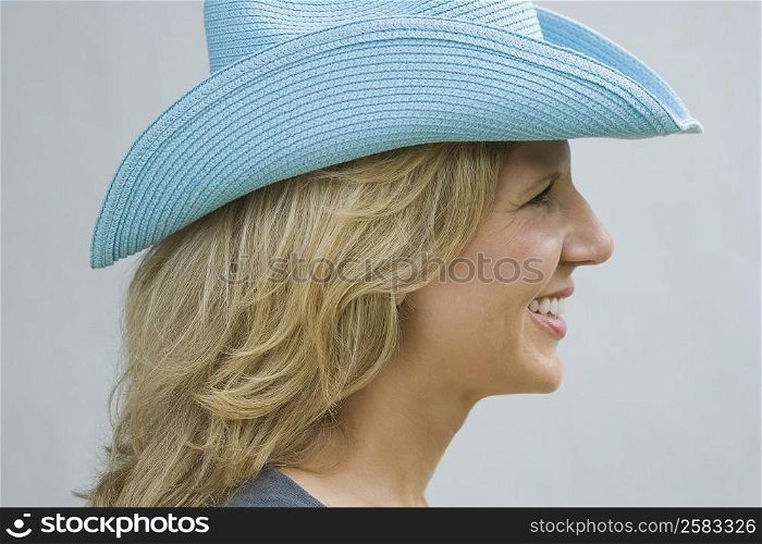 Side profile of a mature woman wearing a cowboy hat and smiling