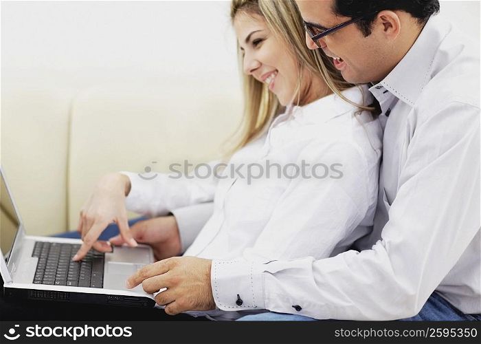 Side profile of a mid adult couple using a laptop