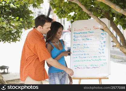 Side profile of a mid adult man and a teenage girl looking at a menu