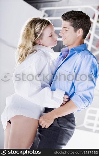 Side profile of a mid adult man and a young woman embracing each other
