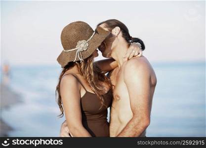 Side profile of a mid adult man and a young woman kissing each other
