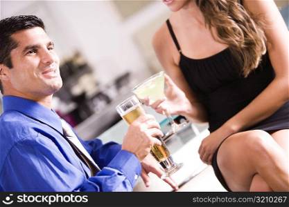 Side profile of a mid adult man and a young woman sitting in a bar