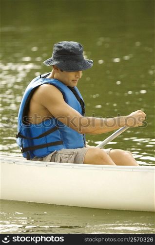 Side profile of a mid adult man boating in a river