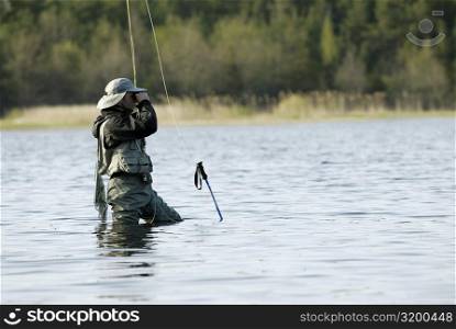 Side profile of a mid adult man fishing in the river