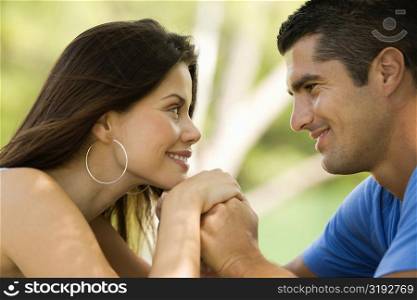 Side profile of a mid adult man looking at a young woman and smiling
