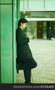 Side profile of a mid adult man operating a mobile phone