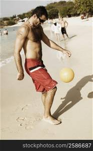 Side profile of a mid adult man playing beach volleyball on the beach