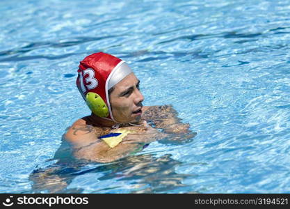 Side profile of a mid adult man playing water polo in a swimming pool