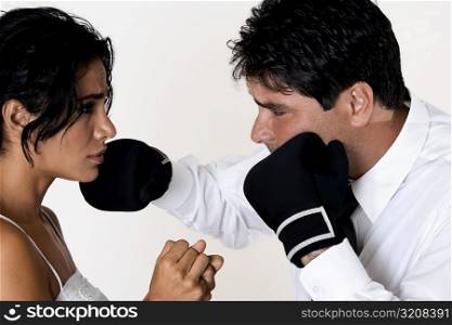 Side profile of a mid adult man punching a young woman