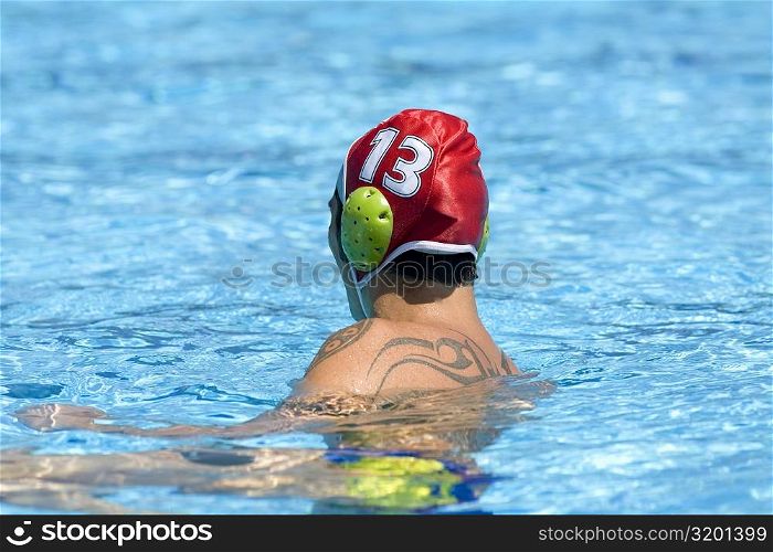 Side profile of a mid adult man swimming in a swimming pool