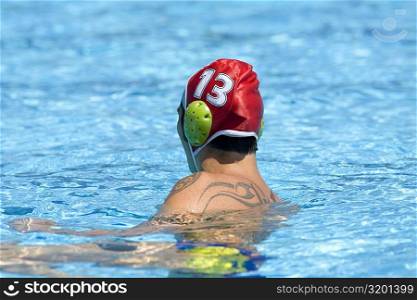 Side profile of a mid adult man swimming in a swimming pool