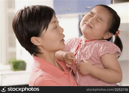 Side profile of a mid adult woman consoling her daughter