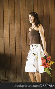 Side profile of a mid adult woman holding a bouquet of flowers