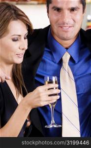Side profile of a mid adult woman holding a glass of champagne with a mid adult man beside her