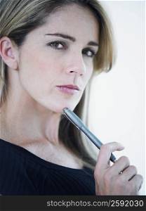 Side profile of a mid adult woman holding a pen