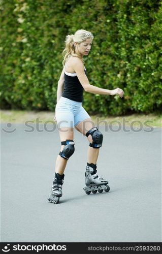 Side profile of a mid adult woman inline skating