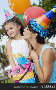 Side profile of a mid adult woman kissing her daughter