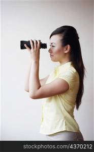 Side profile of a mid adult woman looking through a pair of binoculars
