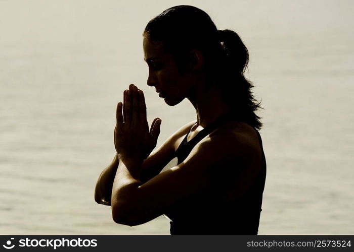 Side profile of a mid adult woman meditating