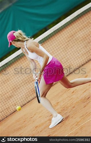 Side profile of a mid adult woman playing tennis