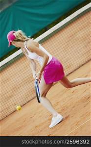 Side profile of a mid adult woman playing tennis