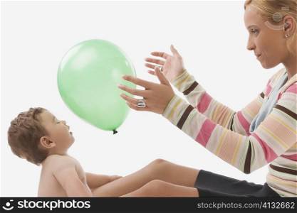 Side profile of a mid adult woman playing with her son