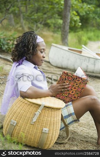 Side profile of a mid adult woman reading a book on the beach
