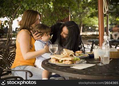 Side profile of a mid adult woman sitting with her son and a mid adult woman in a restaurant, Santo Domingo, Dominican Republic