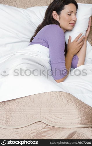 Side profile of a mid adult woman sleeping on the bed