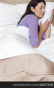 Side profile of a mid adult woman sleeping on the bed