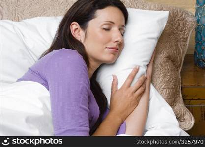 Side profile of a mid adult woman sleeping on the bed