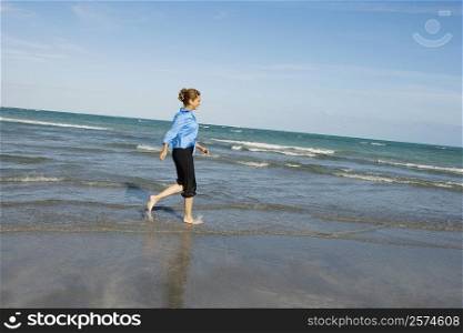 Side profile of a mid adult woman walking on the beach