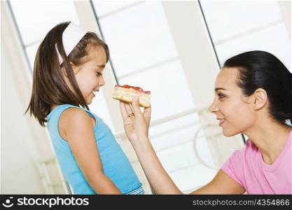 Side profile of a mother feeding her daughter