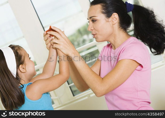 Side profile of a mother holding her daughter&acute;s hands